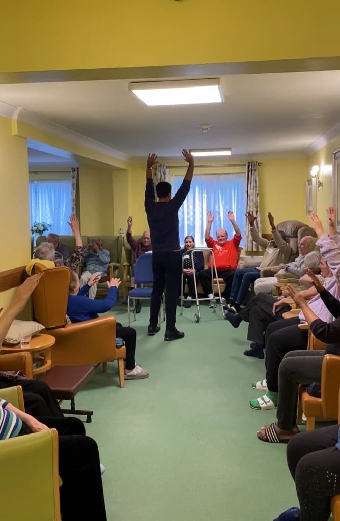 Alex guiding a care home group stretch class